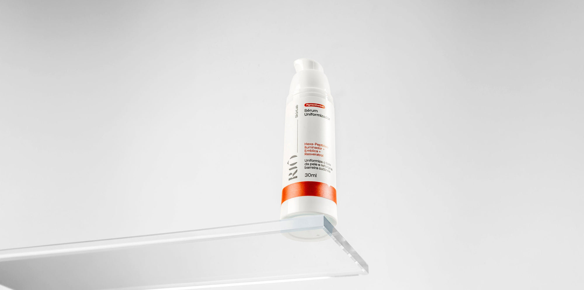 Sérum Uniformizador Riô SkinLab 30ml, com Hexa-Peptídeo Iluminador, Emblica e Resveratrol, apoiado sobre uma placa de acrílico.
